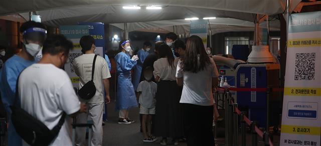 밤에도 북적이는 선별진료소 신종코로나바이러스 감염증(코로나19) 확산세가 계속된 25일 저녁 서울역 임시선별진료소를 찾은 시민들이 검사 대기를 하고 있다.  2022.7.25/뉴스1