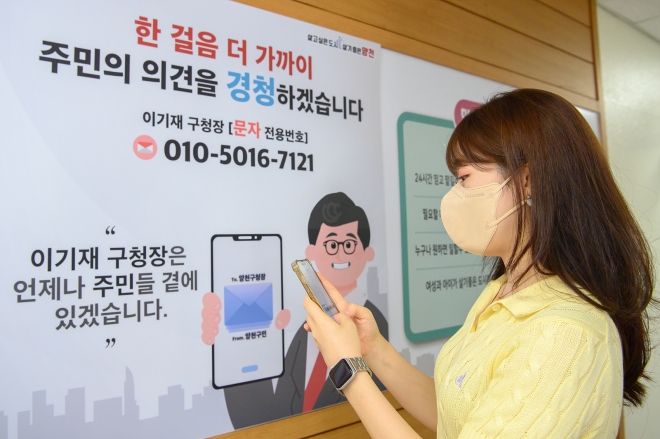이기재 서울 양천구청장이 주민들의 불편 사항과 제안을 직접 듣기 위해 문자 전용 휴대전화를 개설했다. 한 양천구청 관계자가 직통 휴대전화 홍보 포스터 앞에서 직접 구청장에게 문자를 보내고 있다. 양천구 제공 