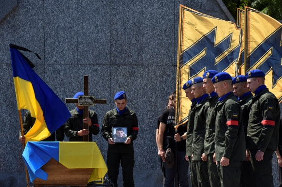 우크라이나 서부 리비우에서 국가방위군 대원들이 남동부 항구도시 마리우폴을 공격한 러시아군과 맞서 싸우다 전사한 아조우 연대 대원들의 장례식에 참석하고 있다. 2022.7.29 로이터 연합뉴스