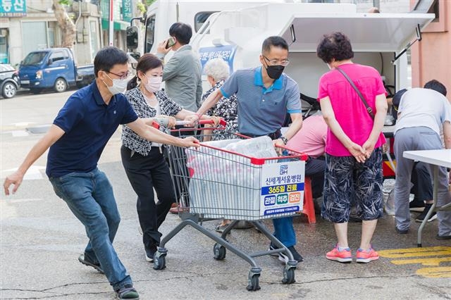 서울 영등포구 직원과 자원봉사자들이 지난달 20일 화재 피해를 입은 문래동 아파트 주민들에게 전달할 생수를 실어나르고 있다. 영등포구 제공