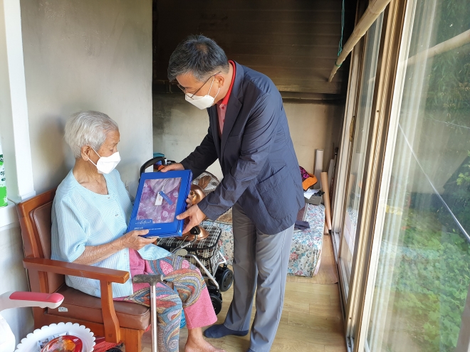 이삼식 옥룡면장이 동동마을에 거주하는 100세 할머니에게 모시 내의를 전달하고 있다. 