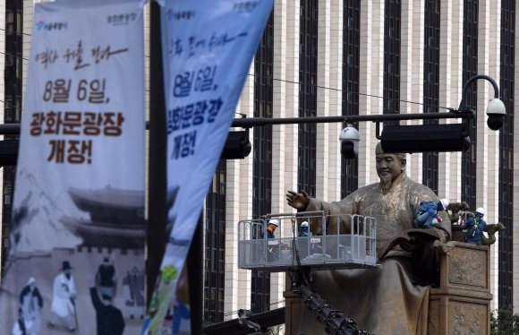 광화문 광장 개장 이틀을 앞둔 4일 서울 광화문광장의 세종대왕 동상을 관계자들이 청소하고 있다. 2022. 8. 4 박윤슬 기자