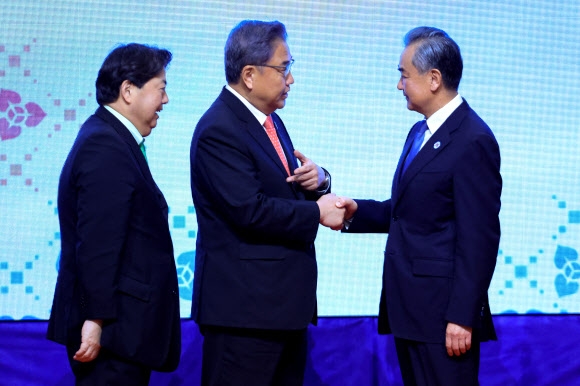 박진(가운데) 외교부 장관과 왕이(오른쪽) 중국 외교부장, 하야시 요시마사(왼쪽) 일본 외무상이 4일 캄보디아 프놈펜 소카호텔에서 열린 아세안+3(한중일) 외교장관회의에서 기념촬영을 마친 뒤 인사하고 있다. 프놈펜 로이터 연합뉴스