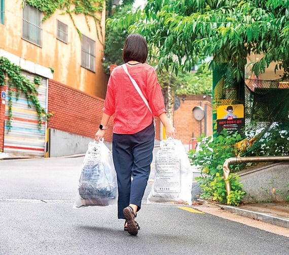 서울 용산구에서 한 주민이 생활 쓰레기를 종량제 봉투에 담아 버리고 있다. 용산구 제공
