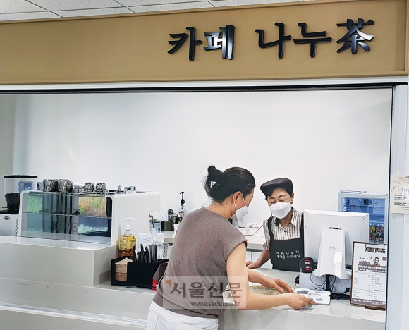 지난 4일 서울 동대문구에 있는 ‘카페 나누다’에서 어르신 바리스타 홍선영(오른쪽)씨가 손님의 주문을 받고 있다.