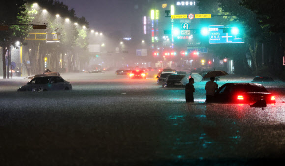 8일 밤 서울 강남구 대치역 인근 도로가 물에 잠기면서 차량과 보행자가 통행하는 데 불편을 겪고 있다. 2022.8.8 <br>연합뉴스