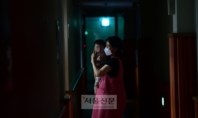 서울아동복지센터에서 박정숙 보육사가 새벽에 잠에서 깬 생후 8개월 된 사랑이(가명)를 안고 복도로 나와 돌보고 있다. 정연호 기자
