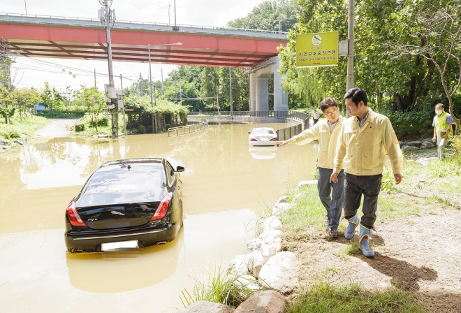 김태우(오른쪽) 서울 강서구청장이 10일 오전 개화 육갑문 현장을 방문해 침수 차량을 살펴보고 있다. 강서구 제공