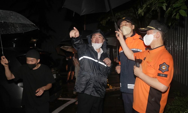 박일하 동작구청장이 지난 8일 저녁 집중호우 피해 지역인 사당2동 극동아파트 축대 붕괴현장을 찾아 소방당국 관계자들과 안전점검을 하고 있다. 동작구 제공.