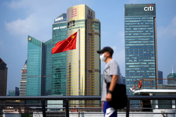 중국 상하이에서 한 남성이 중국 국기 앞을 지나고 있다. 2022.8.2 로이터 연합뉴스