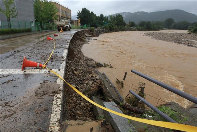 중부지방에 기록적인 폭우가 이어진 9일 오후 경기 광주시 퇴촌면 우산천변 도로 일부가 무너져 내려 있다. 뉴스1