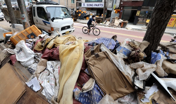 15일 서울 관악구 신사시장 인근 점포 앞 도로에 침수 폐기물들이 쌓여있다. 연합뉴스