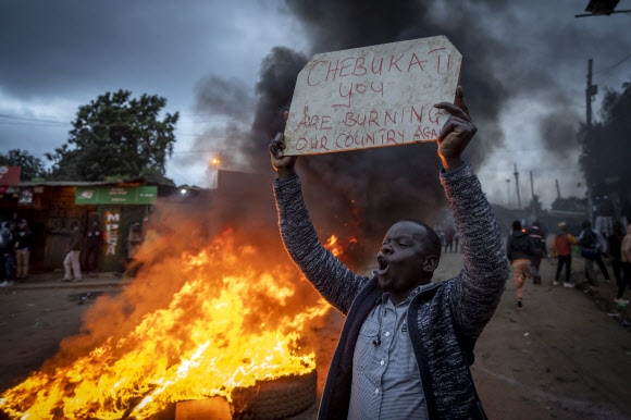15일(현지시간) 케냐 나이로비의 최대 빈민가인 키베라에서 라일라 오딩가 대선 후보의 지지자가 와풀라 체부카티 케냐 선거관리위원회 위원장을 비판하는 플래카드를 들고 시위를 벌이고 있다. 나이로비 AP 뉴시스