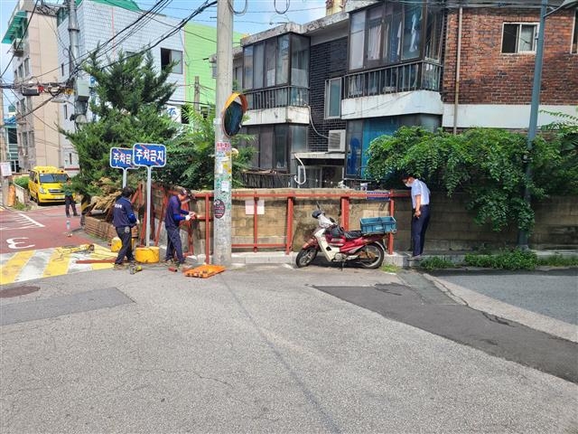 서울 중랑구 관계자와 건축 전문가들이 붕괴 위험이 있는 담장을 보수하고 있다. 중랑구 제공