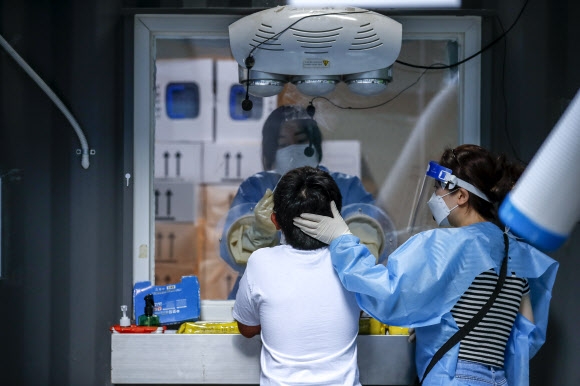 코로나19 검사 받는 소아·청소년 방역 당국이 소아·청소년의 코로나19 백신 접종을 강조한 18일 서울 용산구보건소를 찾은 한 어린이가 검사를 받고 있다.  뉴시스
