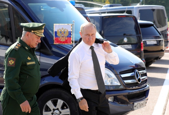 블라디미르 푸틴(오른쪽) 러시아 대통령이 15일(현지시간) 모스크바 외곽 애국공원에서 열린 방위산업 전시회 ‘육군-2022’ 포럼 개막식에 세르게이 쇼이구(왼쪽) 러시아 국방장관과 함께 도착하고 있다. 2022.08.15 AFP 연합뉴스