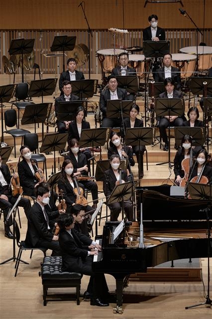 피아니스트 임윤찬(앉은 자리 앞쪽)과 김선욱(뒤쪽)이 지난 20일 서울 롯데콘서트홀에서 열린 ‘클래식 레볼루션 2022’ 무대에서 앙코르 곡인 모차르트 ‘네 손을 위한 피아노 소나타 KV521’ 2악장을 함께 연주하고 있다. 롯데콘서트홀 제공