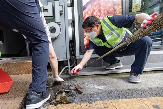 김경호 서울 광진구청장이 지난 18일 광진구 건대입구 ‘맛의 거리’를 청소하고 있다. 광진구 제공