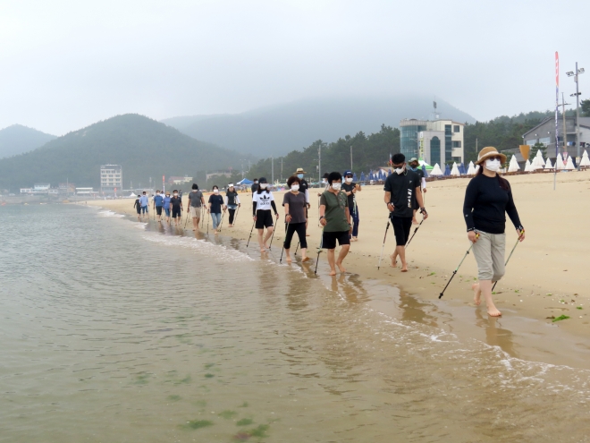 완도군이 지난 7월 22일부터 8월 15일까지 신지명사십리 해수욕장에서 진행한 여름 해양치유프로그램에서 참가자들이 노르딕워킹 체험을 하고 있다.  해양 치유프로그램 노르딕워킹