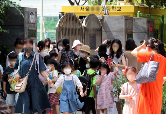 서울 시내 한 초등학교에서 수업을 마친 학생들과 보호자들이 하교하고 있다. 코로나19 재확산 속에 개학을 맞은 학생과 보호자들의 우려가 커지고 있다. 뉴시스.