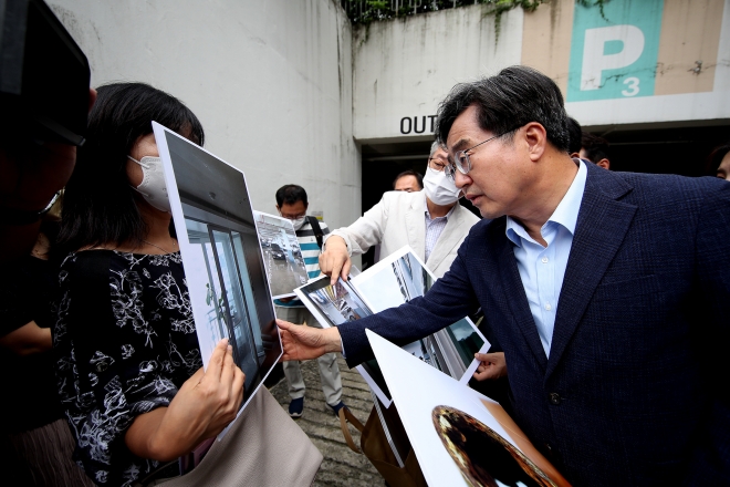 김동연 경기지사가 24일 경기 성남 1기 신도시 한 아파트를 찾아 주민이 보여주는 집안 사진을 보고 있다. 경기도청