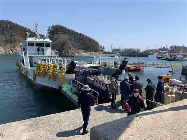 충남 보령시 오천면 호도 주민들이 연료운반선이 도착하자 연료가 동이 난 LPG통을 손수레에 싣고 와 새것과 교체하고 있다. 보령시 제공