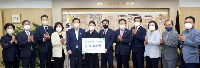 수원시의회 김기정 의장 등 의장단과 시의원, 의회사무국 직원들이 25일 수원시 사회복지협의회에 수해 복구를 위한 성금을 전달하고 있다. 수원시의회 제공