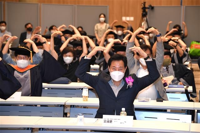 오세훈(맨 앞) 서울시장이 25일 서울시립대에서 열린 노숙인 등 사회 약자를 돕기 위한 특별 교육 프로그램 ‘희망의 인문학’ 수료식에 참석해 팔로 하트 모양을 만들고 있다. 서울시 제공