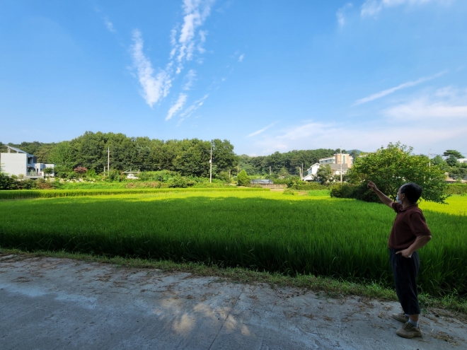 경기 안성시 칠곡면 방삼마을에서 한 주민이 진입로 건설 위치를 설명하고 있다. 방삼마을 뒷산에 물류단지를 개설하며 계획된 4차선 집이로는 사진 왼쪽에 보이는 집과 오른쪽에 보이는 집 가운데를 관통한다.