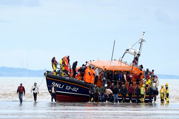 한 무리의 난민들이 영국 왕립인명구조협회(RNLI)의 도움으로 영국 켄트주 도버에 내리고 있다. 2022.8.25 AP 연합뉴스