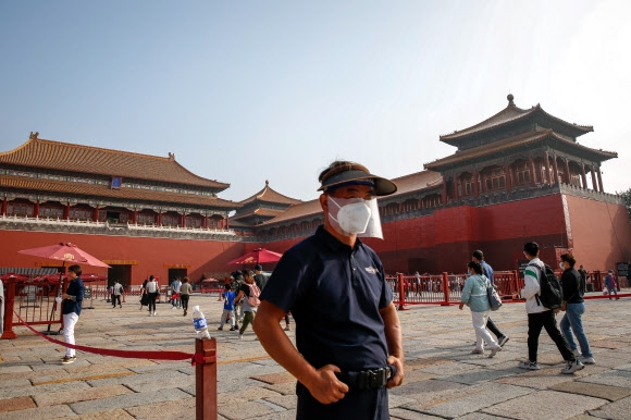 중국 베이징 자금성에서 한 경비원이 마스크와 안면 보호대 등을 착용한 채 서 있다. 2022.8.30 EPA 연합뉴스
