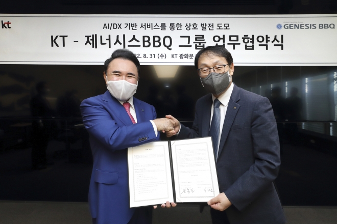 구현모(오른쪽) KT 대표와 윤홍근 제너시스BBQ 회장이 31일 업무협약을 마치고 기념사진을 촬영하고 있다. KT 제공