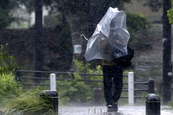 3일 일본 오키나와현 나하시에서 우산을 쓴 남성이 강한 바람을 맞으며 이동하고 있다. 2022.09.04 교도 AP연합뉴스