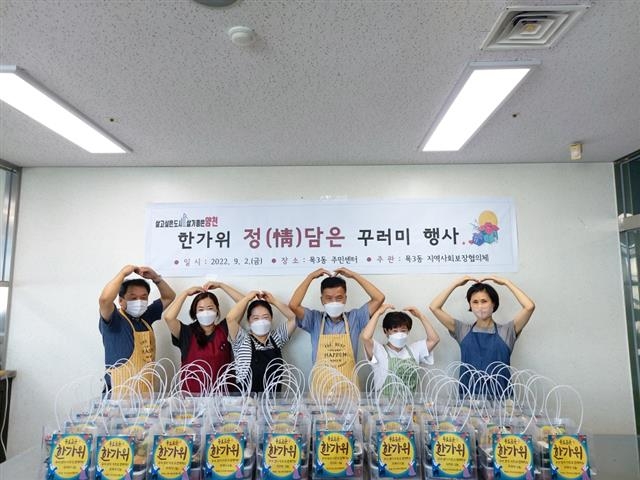 지난 2일 목3동지역사회보장협의체 소속 주민들이 지역 내 홀몸 어르신에게 전달할 음식꾸러미를 만든 뒤 하트를 만들어 보이고 있다. 양천구 제공