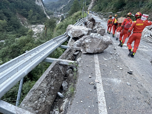 중국 쓰촨성 간쯔장족자치주 루딩현 규모 6.8의 강진이 발생한 가운데 구조대원들이 파손된 도로 옆을 걷고 있다. 6일 인민일보에 따르면 전날부터 발생한 사망자는 65명에 이른다. 2022.9.5 EPA 연합뉴스