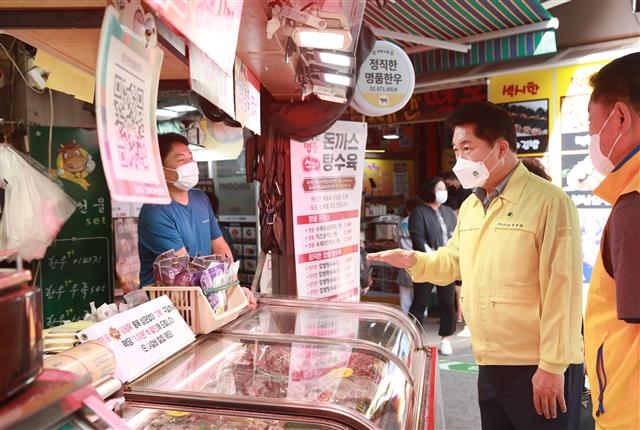 박준희(오른쪽 두 번째) 서울 관악구청장이 지난 6일 지역 전통시장 활성화를 위해 인헌시장을 방문해 현장을 점검하고 상인들과 인사하고 있다. 관악구 제공