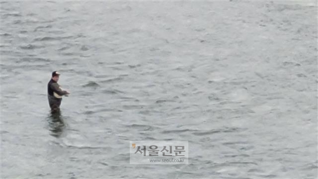 수심이 낮은 경기 연천군 고랑포리와 원당리 사이 임진강에 들어가 낚시하는 사람.