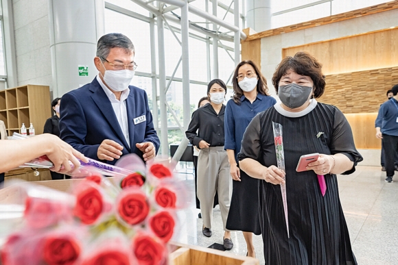 김경호(왼쪽) 광진구청장이 지난 8일 나루아트센터에서 열린 직원 정례조례에서 직원들에게 장미꽃을 건네고 있다.  광진구 제공