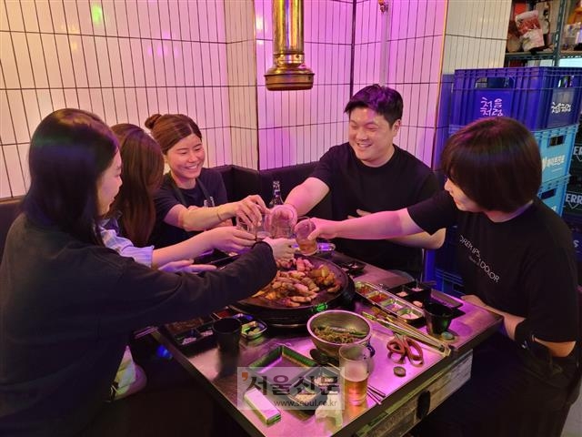 지난 21일 저녁 서울 영등포구 한 식당에서 푸드트럭 대표 간종혁(오른쪽 두 번째)씨와 직원들이 삼겹살 회식을 하며 잔을 부딪치고 있다. 푸드트럭의 좁은 공간에서 유기적으로 일하려면 무엇보다 직원들 간의 화합이 중요하다. 신융아 기자