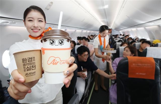 제주항공 승무원이 플라스틱 줄이기 캠페인의 일환으로 친환경 재질로 교체된 종이컵을 승객들에게 나눠 주고 있다. 제주항공 제공