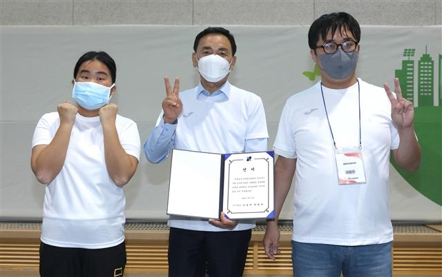 조성명(가운데) 강남구청장이 지난 22일 오전 일원동 밀알학교에서 열린 ‘2022 어깨동무스페셜운동회’에서 개막 선서를 한 발달장애인 원희재(왼쪽)·강동연씨와 함께 선서문을 들고 기념촬영을 하고 있다. 강남구 제공