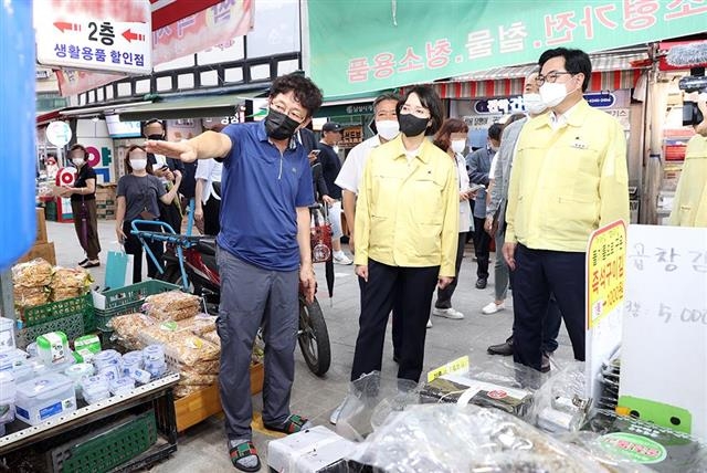 박일하(오른쪽) 서울 동작구청장과 이영 중소벤처기업부 장관이 지난달 19일 남성사계시장 수해 현장을 찾아 상인들의 애로사항을 청취하고 있다. 동작구 제공