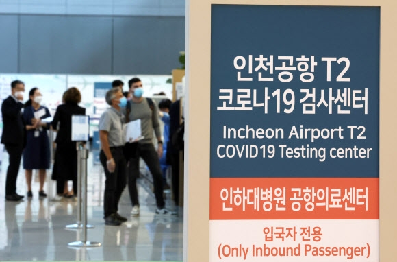 해외 입국자들이 29일 인천국제공항 2터미널 코로나19 검사센터에서 검사를 기다리고 있다. 정부는 10월 1일부터 해외 입국자의 PCR(유전자증폭) 검사 의무를 면제하기로 했다.  연합뉴스