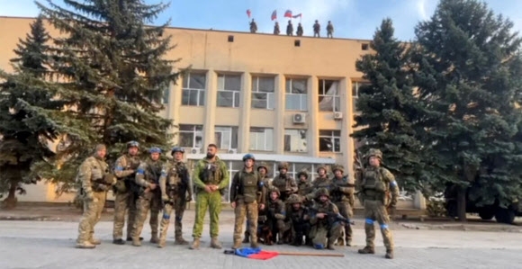 우크라이나군이 도네츠크주 리만 시청 건물 앞에서 리만 탈환 소식을 알리고 있다. 2022.10.1 우크라이나군 81 공수여단 제공 로이터 연합뉴스