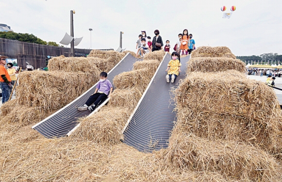 지난달 30일 서울 송파구 올림픽공원 평화의 문 일대에서 열린 ‘한성백제문화제’에서 아이들이 지푸라기 미끄럼틀을 체험하는 모습.  송파구 제공