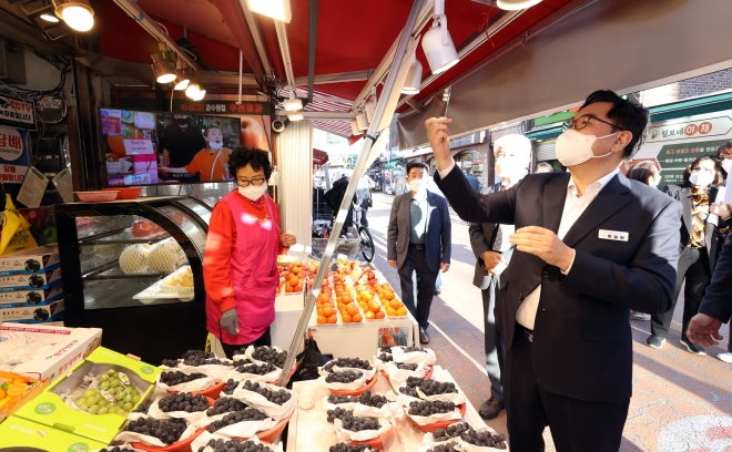 박일하 서울 동작구청장이 11일 성대전통시장을 방문해 지역화폐를 이용해 과일을 구매하고 있다. 동작구 제공.