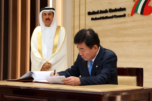 아프리카·중동 순방 중인 김진표(오른쪽) 국회의장이 14일(현지시간) 아랍에미리트(UAE)의 수도 아부다비 연방평의회 건물에서 사끄르 고바시 연방평의회 의장과 회담하기 전 방명록에 서명하고 있다. 국회의장실 제공