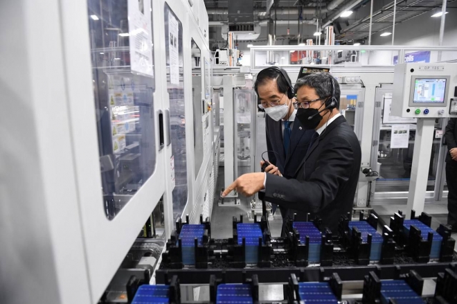 한덕수(왼쪽) 국무총리가 미국 조지아 한화큐셀 공장에서 최병용 공장장에게 자동화된 태양광 생산라인에 대한 설명을 듣고 있다. 한화큐셀 제공