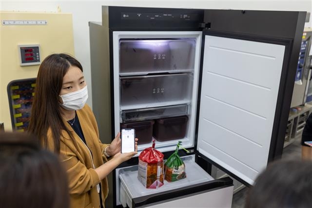 지난달 6일 경남 창원 스마트파크에서 LG전자 연구원이 시중에 판매되는 포장김치를 최적의 상태로 보관할 수 있는 ‘디오스 오브제컬렉션 김치냉장고 무드업’의 인공지능 맞춤 보관 기능에 대해 설명하고 있다.  LG전자 제공