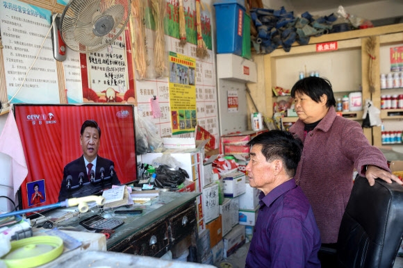 제20차 중국 공산당 전국대표대회가 개막한 16일 안후이성 북부도시 화이베이의 한 상점에서 주민들이 TV로 시진핑 국가주석의 개막식 연설을 보고 있다. 화이베이 AFP 연합뉴스